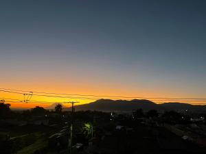 a sunset over a city with mountains in the background at Room503SanSalvador in San Salvador