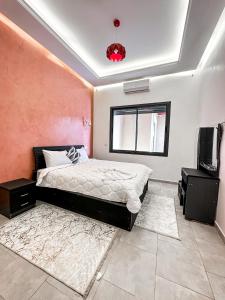 - une chambre avec un lit et une télévision dans l'établissement Villa Marrakesh White Dreams, à Marrakech