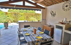 a table and chairs in a patio with a kitchen at Maison Le Pavillon in Graveson