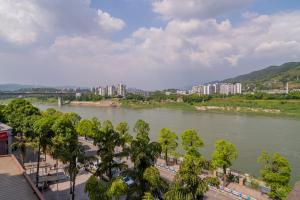 Blick auf einen Fluss mit Bäumen und Gebäuden in der Unterkunft Wuyu Hotel Chongqing Jinyun Mountain Southwest University in Chongqing