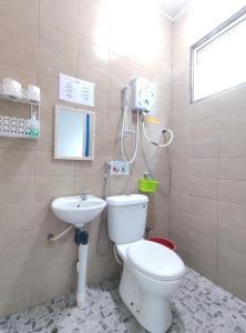 a bathroom with a toilet and a sink at Nulu View Cabin in Kundasang