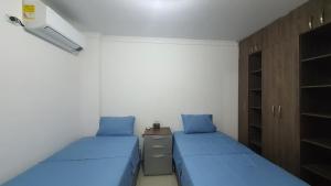 a small room with two beds and a cabinet at Kiosco Azul - Apartamento amoblado cerca al mar in Ríohacha