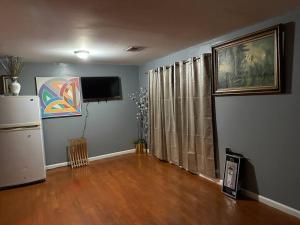 a living room with a television and a hard wood floor at Guest House Master's Bedroom with Private Bathroom, 6 mins to Newark Liberty International Airport Penn Station Prudential New York It is central close to major places in Newark