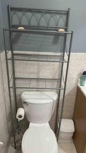 a bathroom with a toilet and a shelf above it at Guest House Master's Bedroom with Private Bathroom, 6 mins to Newark Liberty International Airport Penn Station Prudential New York It is central close to major places in Newark