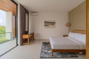 1 dormitorio con cama y escritorio en Villa Sagrada in Canggu Bali, en Dalung