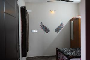 a bedroom with two wings on the wall at Shobha Comforts in Chikmagalūr