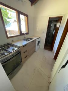 cocina con fregadero y fogones horno superior en Casa con vista al lago en San Carlos de Bariloche