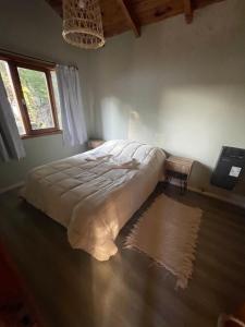 1 dormitorio con 1 cama en una habitación con ventana en Casa con vista al lago en San Carlos de Bariloche