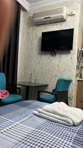 a room with a bed with chairs and a tv on the wall at İstiklal hostel istanbul in Istanbul