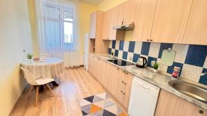 a small kitchen with a table and a sink at Светлая квартира , с видом на набережную. in Astana