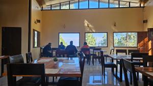 a group of people sitting at tables in a restaurant at Shiv Forest Villas in Pauri
