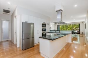 a kitchen with white cabinets and a stainless steel refrigerator at Serpentine Park on View in Bendigo