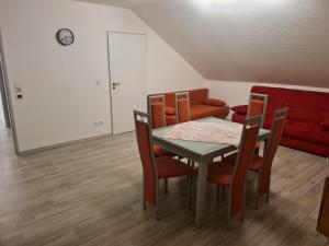 una sala da pranzo con tavolo, sedie e divano di Admira DGL, Monteurwohnung a Geeste