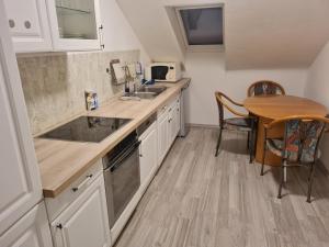 a kitchen with white cabinets and a wooden table at Admira DGL, Monteurwohnung in Geeste