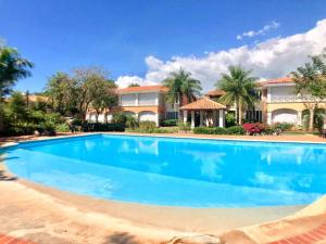 uma grande piscina em frente a uma casa em Lovely 2 Bedroom Apartment with Pool Front em Los Conucos