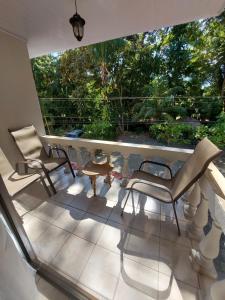 a balcony with two chairs and a table at Casa Arenas in Manuel Antonio