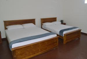 twee bedden naast elkaar in een kamer bij Oceanic Shades - Mount Lavinia in Mount Lavinia