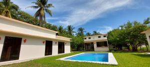 a house with a swimming pool in the yard at Rancho Lyon Playa Costa Azul in Sonsonate