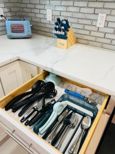 a drawer in a kitchen filled with utensils at Charming Luxury House in Largo