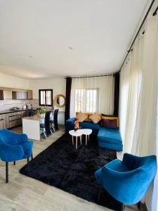 a living room with a blue couch and a table at Yvanka Appart'City Antsirabe in Antsirabe