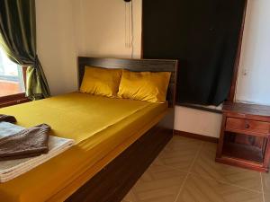 a bed with yellow sheets and pillows in a room at White Rose Guesthouse in Koh Rong Island