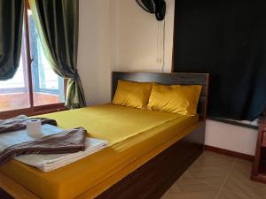 1 dormitorio con 1 cama con sábanas amarillas y ventana en White Rose Guesthouse, en Koh Rong