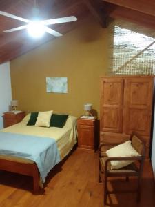 een slaapkamer met 2 bedden en een stoel in een kamer bij El Elyon Duplex in Santa Rosa de Calamuchita