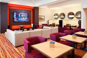 a restaurant with purple chairs and a flat screen tv at Courtyard by Marriott Pueblo in Pueblo