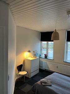 una camera con letto, scrivania e sedia di Tønders bedste udsigt et værelse stue spisestue køkken badeværelse a Tønder
