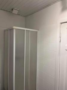 a bathroom with a shower and a white cabinet at Tønders bedste udsigt et værelse stue spisestue køkken badeværelse in Tønder