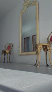 um espelho e um banco em frente a um espelho em Adriatica Apartamentos em San Luis