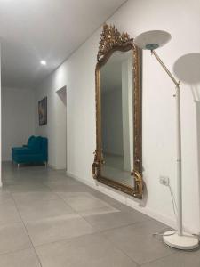 um espelho numa parede ao lado de um sofá azul em Adriatica Apartamentos em San Luis