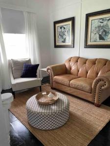 uma sala de estar com um sofá e uma mesa de centro em Comfy Queenslander Cottage em Brisbane