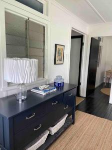 a black dresser in a room with a window at Comfy Queenslander Cottage in Brisbane