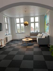 sala de estar con sofá y mesa en Tønders bedste udsigt et værelse stue spisestue køkken badeværelse, en Tønder
