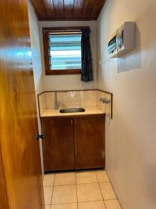 niewielka łazienka z umywalką i oknem w obiekcie Sunset View-Villa w mieście Pacific Harbour