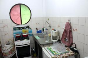 a small kitchen with a stove and a counter top at Casa de Alvenaria- Mauá in Mauá +17 photos