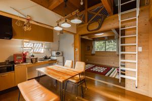 eine Küche und ein Esszimmer mit einem Tisch und Stühlen in der Unterkunft 舞鶴ふるるファームコテージ in Maizuru