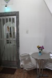 a table and chairs in a room with a door at Casa de Alvenaria- Mauá in Mauá