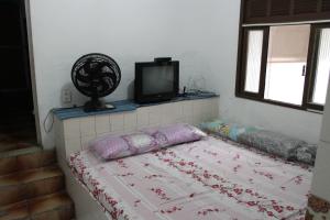 a bedroom with a bed with a tv on top at Casa de Alvenaria- Mauá in Mauá