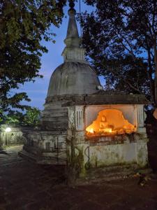 an old stone monument with flames in it at night at Little Pumpkin Cabanas in Tangalle