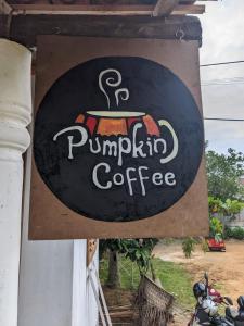 a sign for a pumpkin coffee sign on a building at Little Pumpkin Cabanas in Tangalle