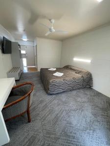 a room with a bed and a chair in it at The Park Motel in Charters Towers