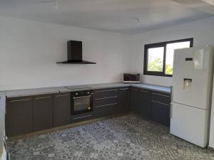 a kitchen with a white refrigerator and a window at Villa Panoramique in Le Tampon