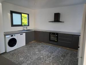 a kitchen with a washing machine and a window at Villa Panoramique in Le Tampon