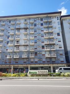 a large apartment building with a sign in front of it at Amaia Steps Capitol Central N814 in Bacolod