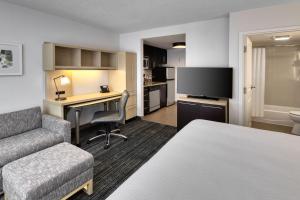 a hotel room with a bed and a desk with a computer at TownePlace Suites by Marriott Sudbury in Sudbury