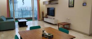 a living room with a table and chairs and a tv at GM Hospitality Services pune in Pune