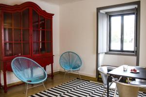 a room with two chairs and a table and a cabinet at Pensao Sisudo in Sintra