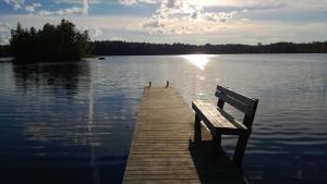 a bench sitting on a dock on a lake at Tervalepikon Torpat in Sysmä